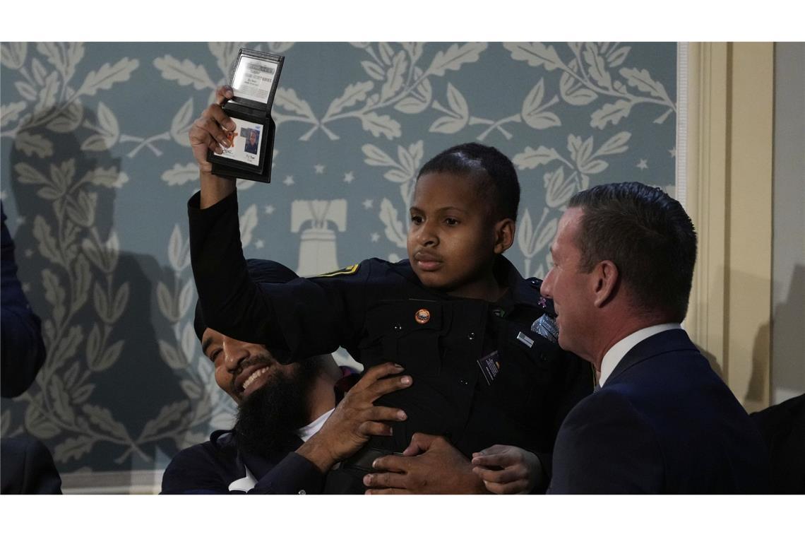 US-Präsident macht kleinen Jungen mit Gehirntumor zum Geheimagenten Devarjay „DJ“ Daniel hält einen Ehrenausweis des US-Geheimdienstes in der Hand, den ihm der Direktor des US-Geheimdienstes Sean Curran überreicht hat.