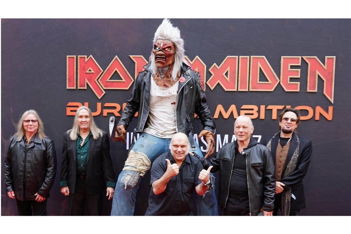 Die Bandmitglieder von Iron Maiden bei der Weltpremiere des Dokumentarfilms „Burining Ambition“ – Maskottchen Eddie darf natürlich nicht fehlen.