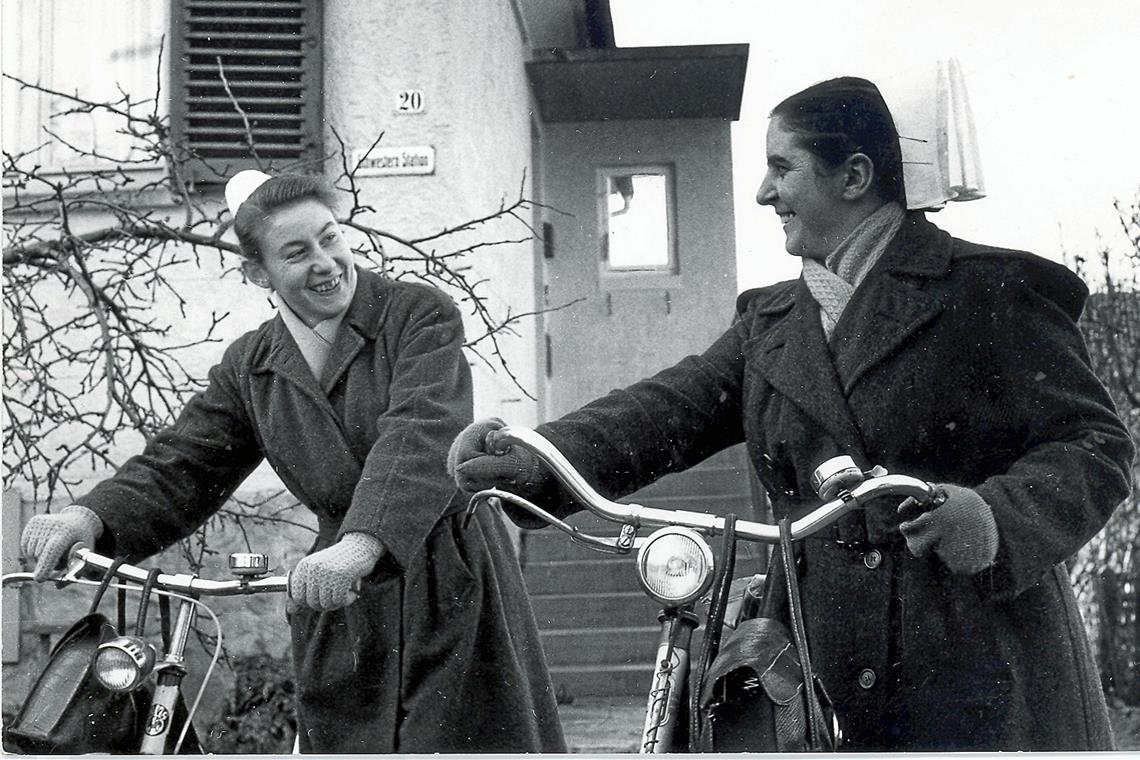 125 Jahre Krankenpflegeverein: Pioniere der Pflege in Murrhardt Die beiden Gemeindeschwestern Hanne Fetzer und Meta Wörner (von links), die mit Fahrrädern unterwegs waren, 1964 vor dem Aufgang zur Schwesternstation. Das modernisierte Gebäude ist heute der Sitz von Diakonie ambulant. Fotos: Diakoneo/Diak-Archiv Schwäbisch Hall