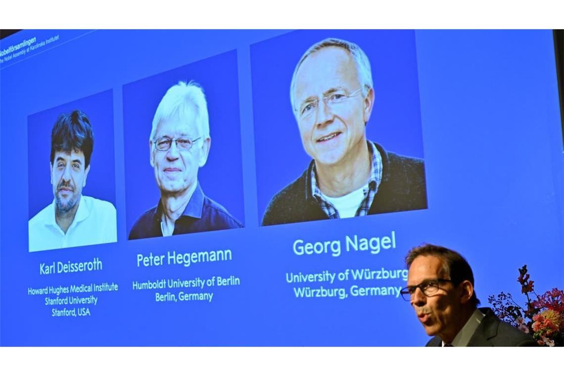 Die Bilder von Karl Deisseroth, Peter Hegemann und Georg Nagel sind auf einem Monitor zu sehen, als ihnen der Nobelpreis für Physiologie oder Medizin 2026 verliehen wird. Dies wird im Rahmen einer Pressekonferenz im Nobel-Forum am Karolinska-Institut in Stockholm, Schweden, bekannt gegeben.
