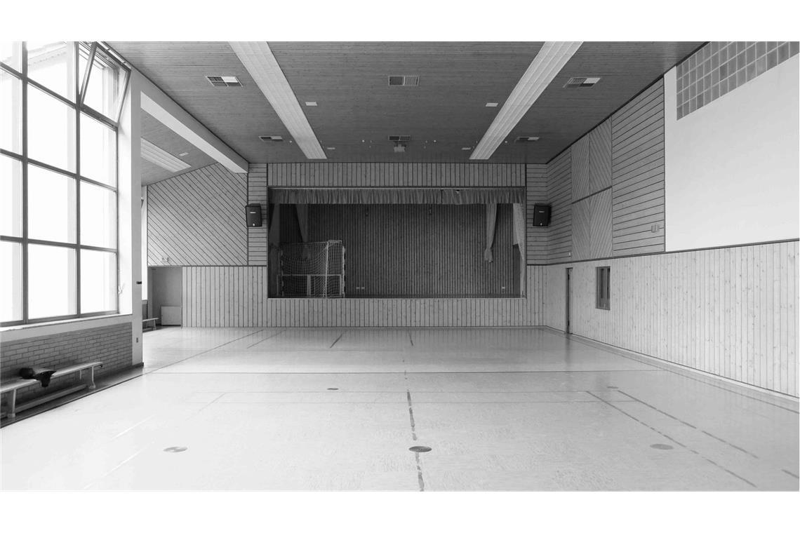 Junge Stuttgarter Architekten entwerfen ein Haus fürs ganze Dorf Die Bühne in der Halle vor dem Umbau. Die Holzverkleidung wurde abgebaut – den Rückbau organisierten die örtlichen Vereine – und die Leistenschalung lebt als Fassade einer Waldhütte weiter.
