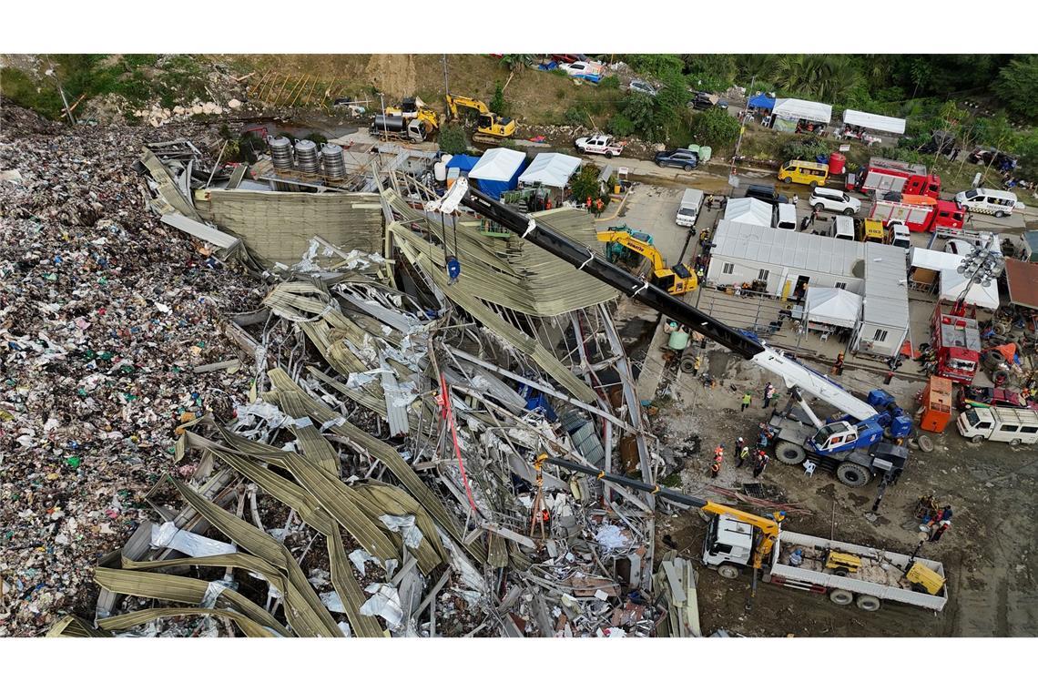 Die Einsatzkräfte suchen unter anderem mit einem Kran in den Abfall-Massen.