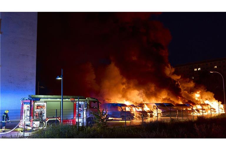 Die Feuerwehr versucht nach einem mutmaßlichen Brandanschlag in Berlin-Lichtenberg brennende Kleintransporter zu löschen.