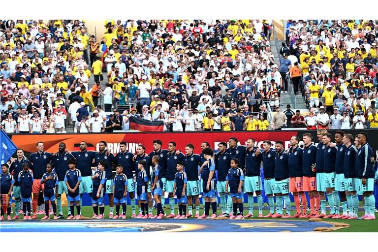 Die Fußball-Nationalmannschaft steht beim Abspielen der Nationalhymne am Mittelkreis.