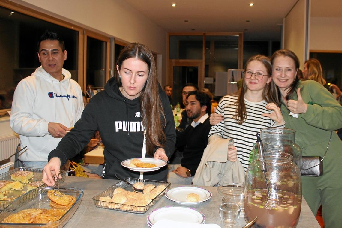 Ein Abend, der im Zeichen von Neubeginn und Begegnung steht Die Gäste versorgen sich am reich bestückten Büfett und sind gut gelaunt. Foto: privat
