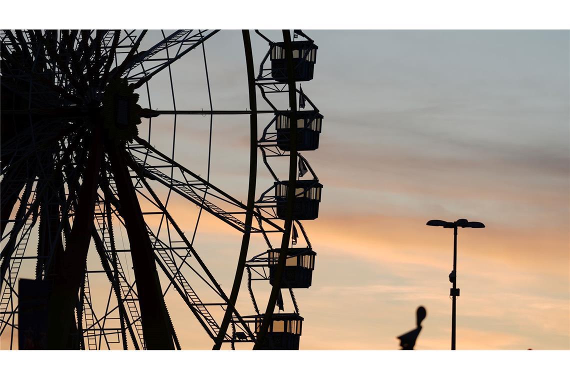 Die Gondeln vom Riesenrad auf dem Hamburger Winterdom auf dem Heiligengeistfeld sind vor dem Abendhimmel zu sehen.