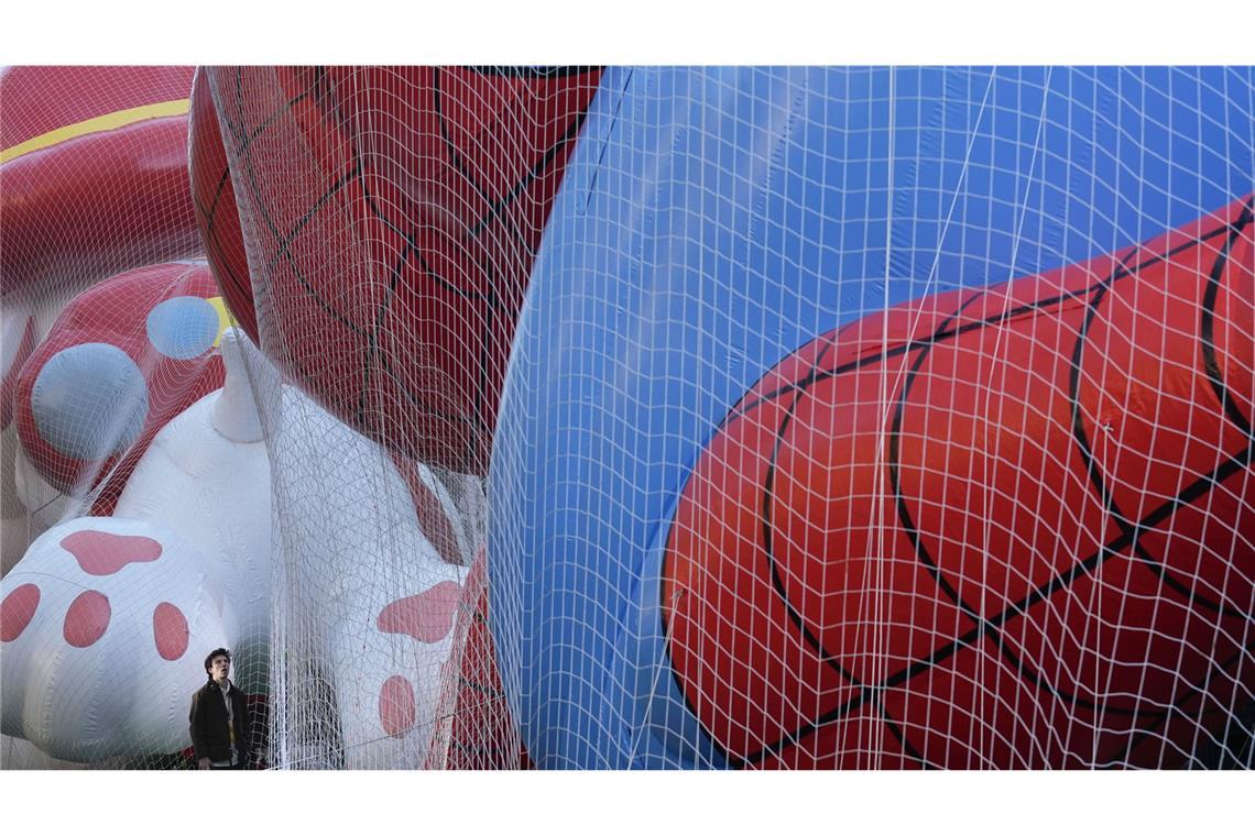 Ballons und Tanzgruppen in den Straßen New Yorks Die Größe der Riesen-Ballons wird deutlich, wenn ein Mensch daneben steht. Spider-Man ist laut Macy’s so hoch wie ein vierstöckiges Haus.