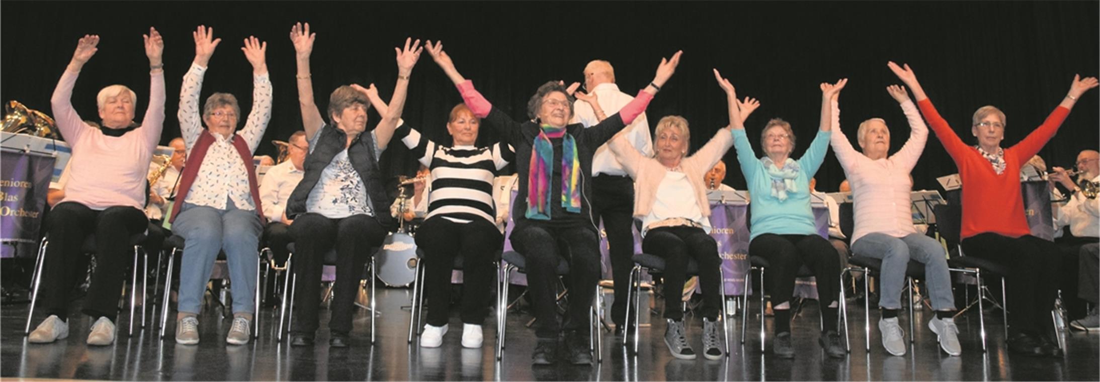 Bei der Sitzgymnastik machen alle mit Die Gymnastikdamen zeigen ihre Übungen auf der Bühne (von links): Johanna Stettner, Brigitte Lucht, Irmgard Domnik, Sabine Weiß, Gudrun Gruber, Marianne Obergföll, Anneliese Gierschner, Gretel Altvater und Gerlinde Schümann. Foto: E. Klaper