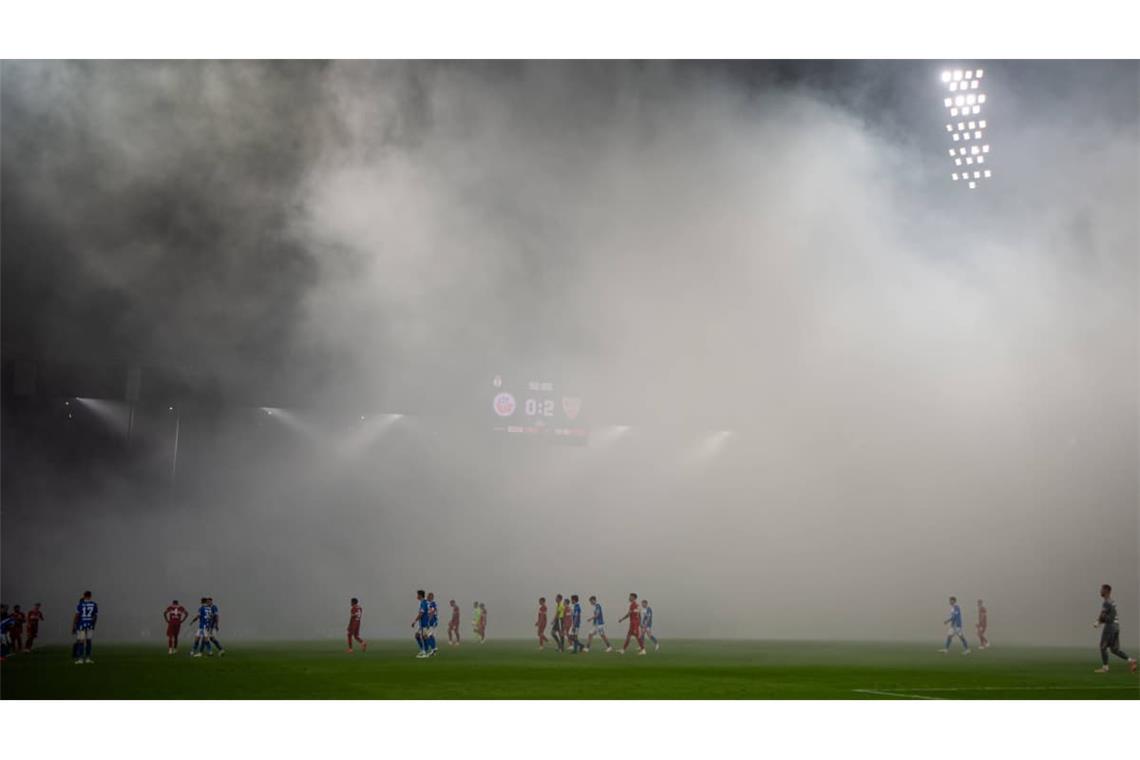 Die Hansa-Fans begleiten den Wiederanpfiff mit mehreren Rauchtöpfen, die die Sichtverhältnisse auf dem Platz trüben. Der Unparteiische unterbricht daher die Partie für mehrere Minuten.