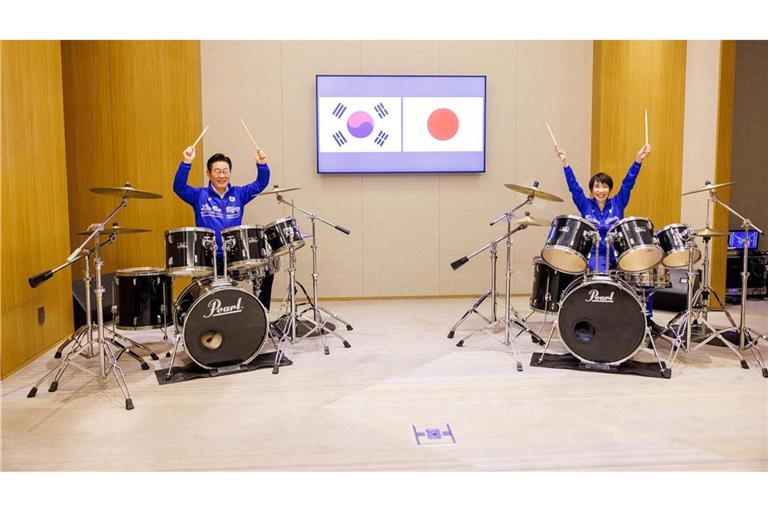 Die japanische Ministerpräsidentin Sanae Takaichi (r) und der südkoreanische Präsident Lee Jae Myung spielen Schlagzeug.