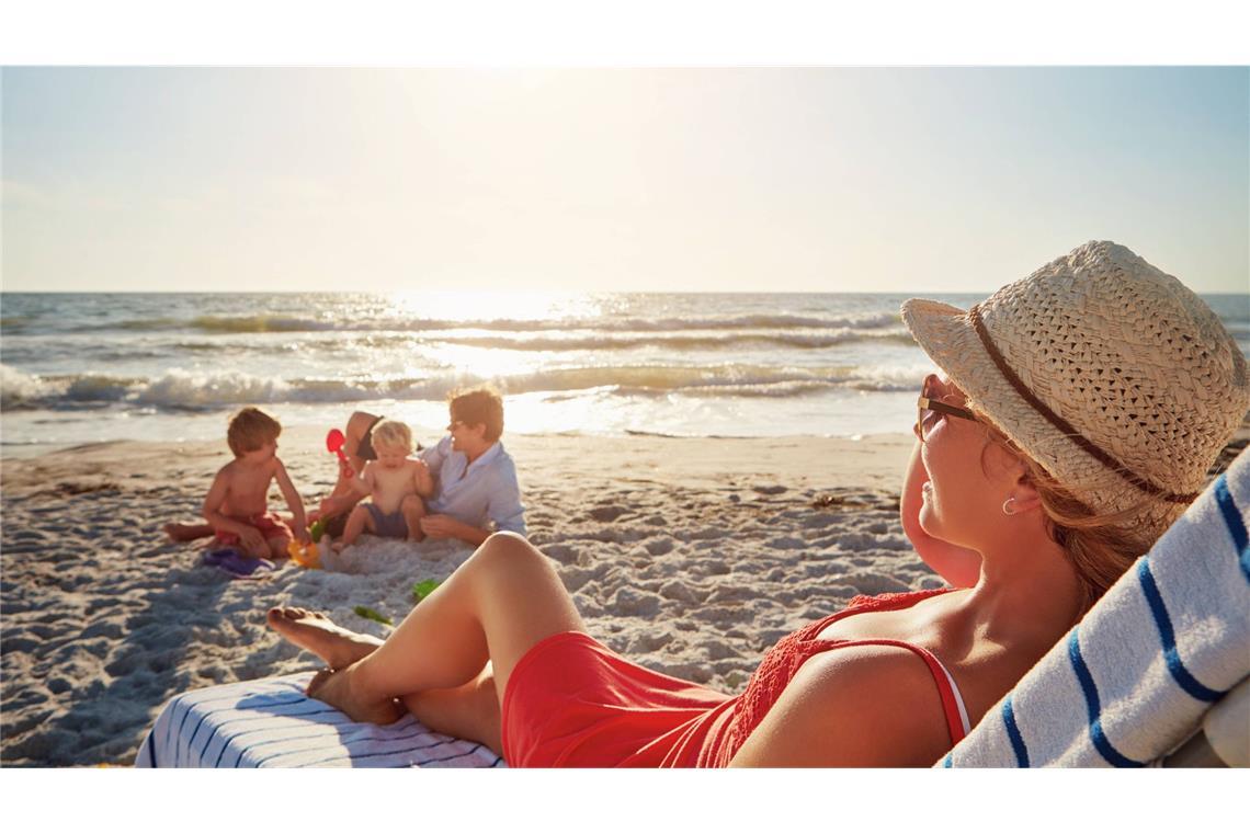Die Kinder buddeln,  die Mutter ruht sich aus – so stellt man sich den Familienurlaub  vor. Oft geht es allerdings weniger entspannt zu.