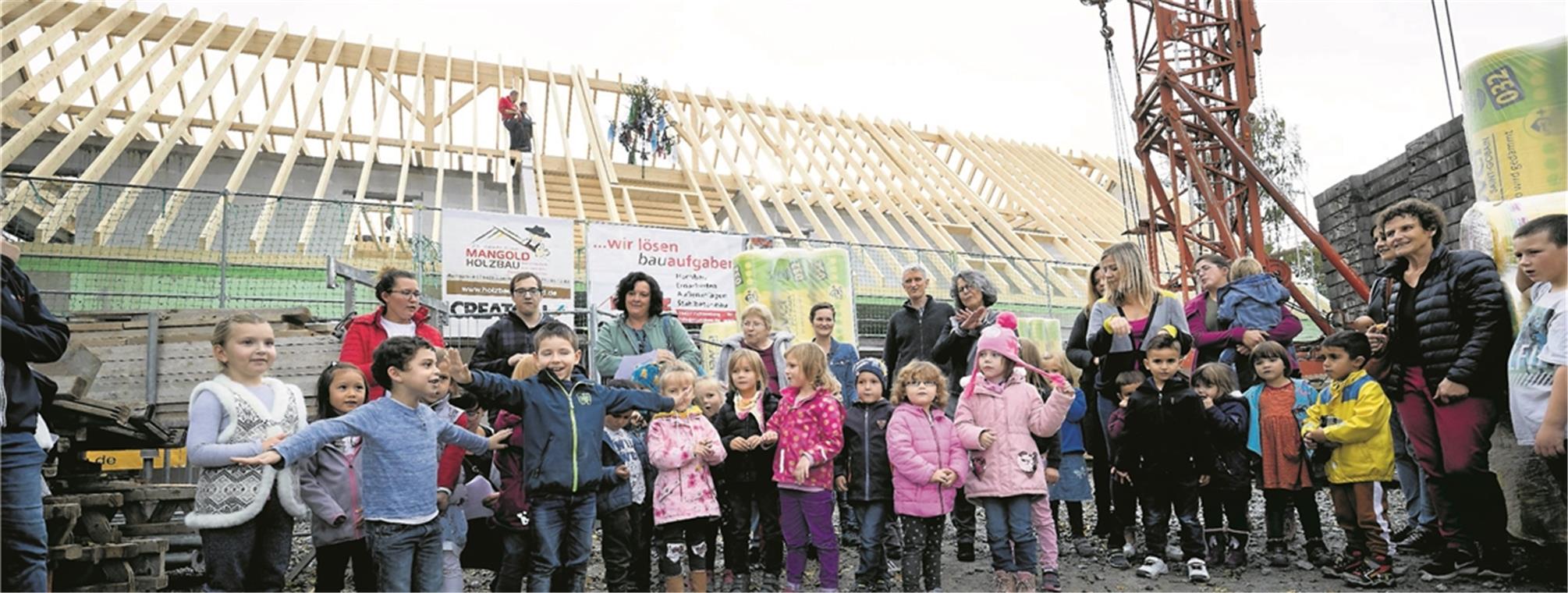 Kindergarten und Familienzentrum: Halbzeit für künftige Heimat Die Mädchen und Jungen singen beim Richtfest augenzwinkernd: „Ich kenn ein Haus, da schauen viele Kinder raus“. Foto: J. Fiedler