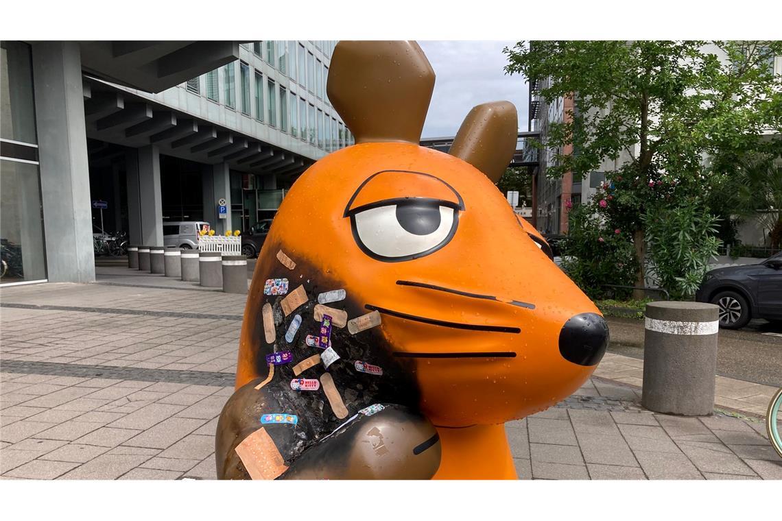 Angebrannte Maus-Figur wird mit Pflastern versorgt