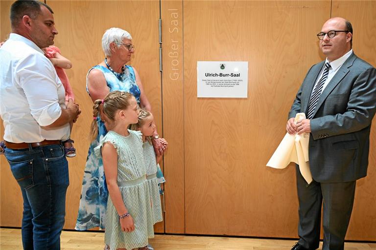 Die Mitglieder der Familie vor der Namenstafel mit (von links) Ulrich Burrs Sohn Stefan mit Tochter Eva auf dem Arm (verdeckt), Witwe Angelika Burr mit ihren Enkelinnen Emilia und Leonie sowie Bürgermeister Armin Mößner. Foto: Elisabeth Klaper
