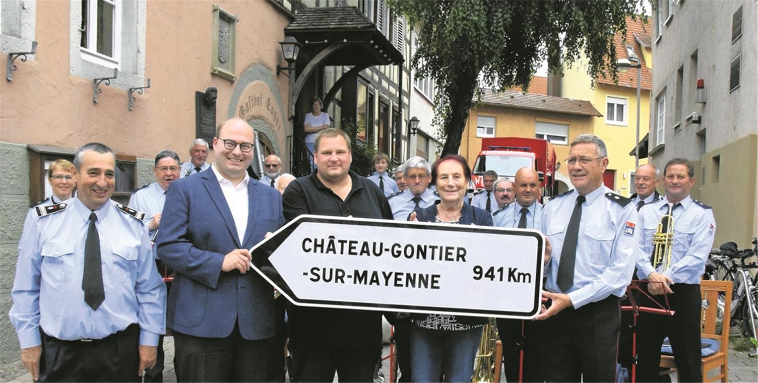 Die Mitglieder der Harmonie haben ein Geschenk mitgebracht – einen nagelneuen Wegweiser nach Château-Gontier-sur-Mayenne. Die Aufnahme von der Übergabe zeigt (von links vorne) den musikalischen Leiter Didier Veillard, Bürgermeister Armin Mößner, Feuerwehr-Vizekommandanten Stefan Krehan, Altstadträtin Michèle Hartmann und Harmonie-Vorsitzenden Alain Gautreau. Foto: E. Klaper