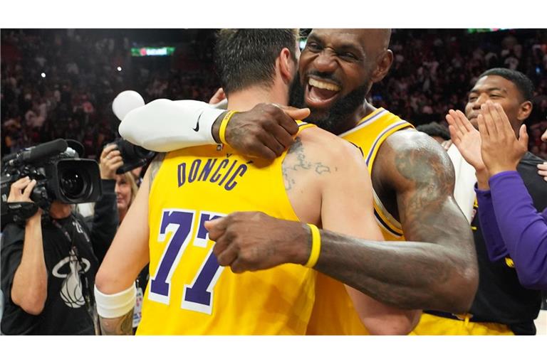 Die NBA-Stars Luka Doncic (l) und LeBron James von den Los Angeles Lakers umarmen sich nach ihrem Sieg gegen die Miami Heat.