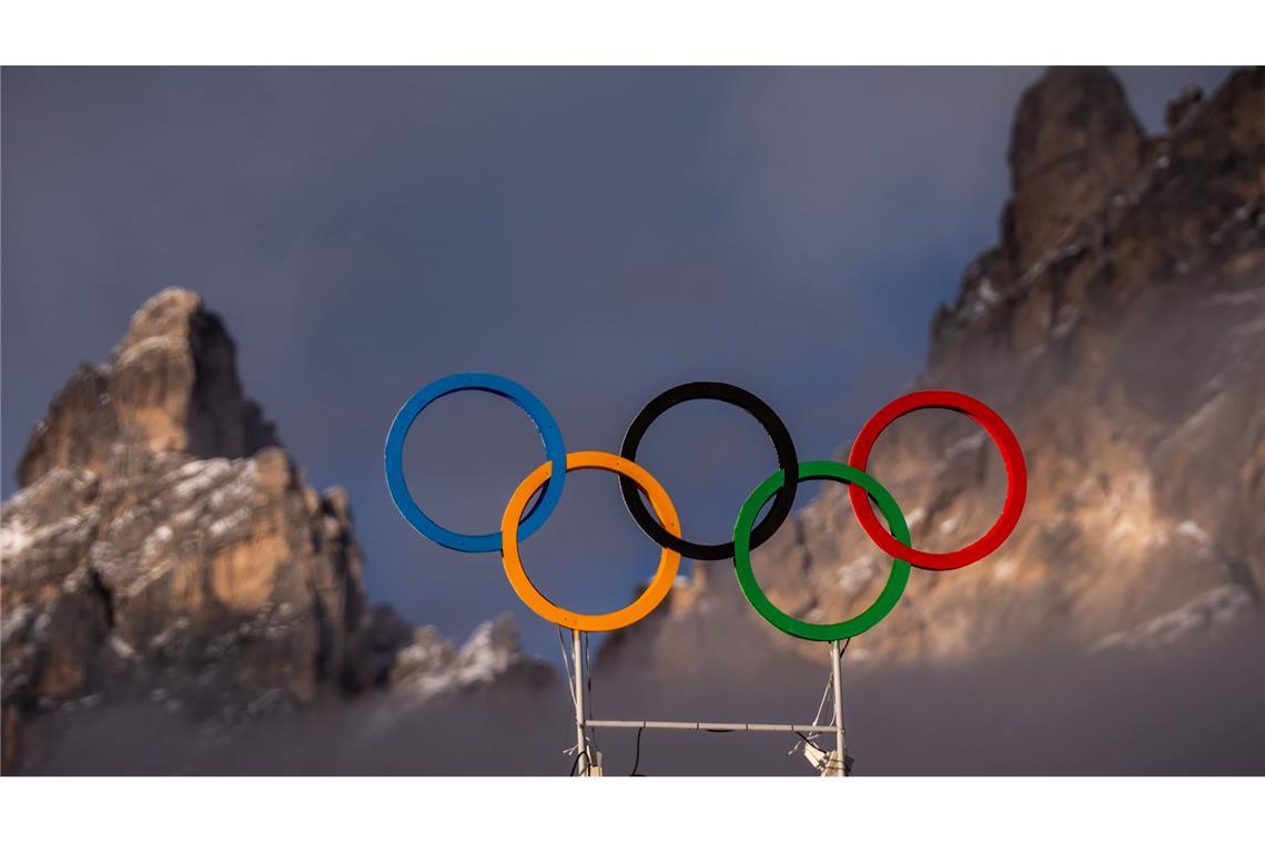 Die Olympischen Ringe auf dem Dach der Curling Halle sind vor den Bergen in Cortina zu sehen. Die Olympischen Winterspiele 2026 finden in Mailand und Cortina d'Ampezzo statt.