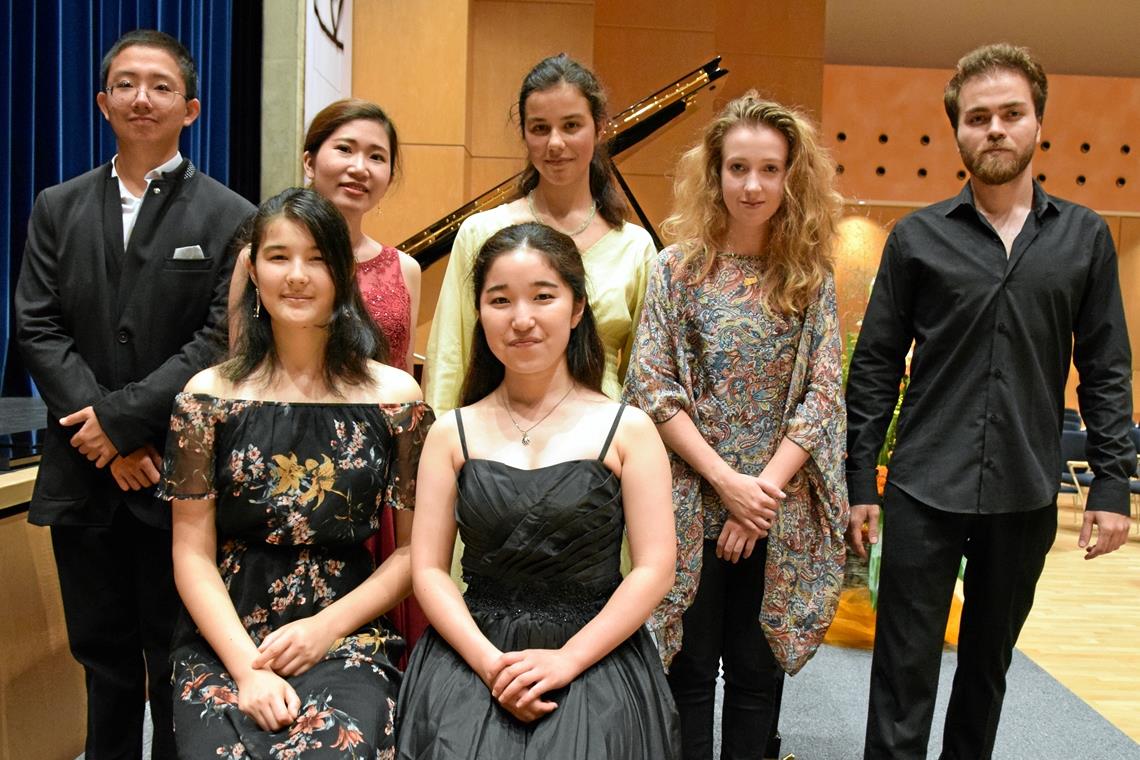 Werke aus vier Epochen haben fulminanten Auftritt Die Pianistinnen und Pianisten des Abends (von links): Dezheng Kong, Maria Litsoukov (sitzend), Rei Naito, Nanae Maruyama (sitzend), Louisa Sophia Jefferson, Alice Power und Arkın Akçagül. Foto: Elisabeth Klaper