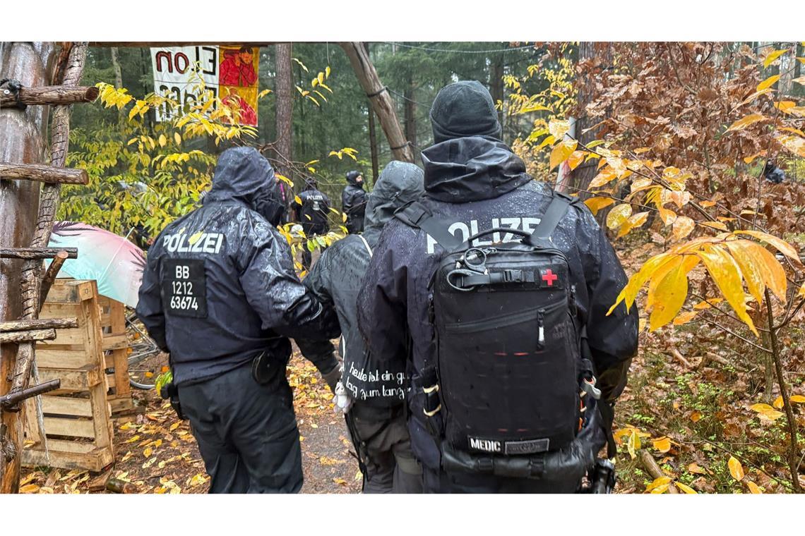 Bilder des Tages Die Polizei löst das Protestcamp von Tesla-Gegnern im Wald nahe der Tesla-Autofabrik in Grünheide in Brandenburg auf. Dabei führen Polizisten einen Aktivisten ab.
