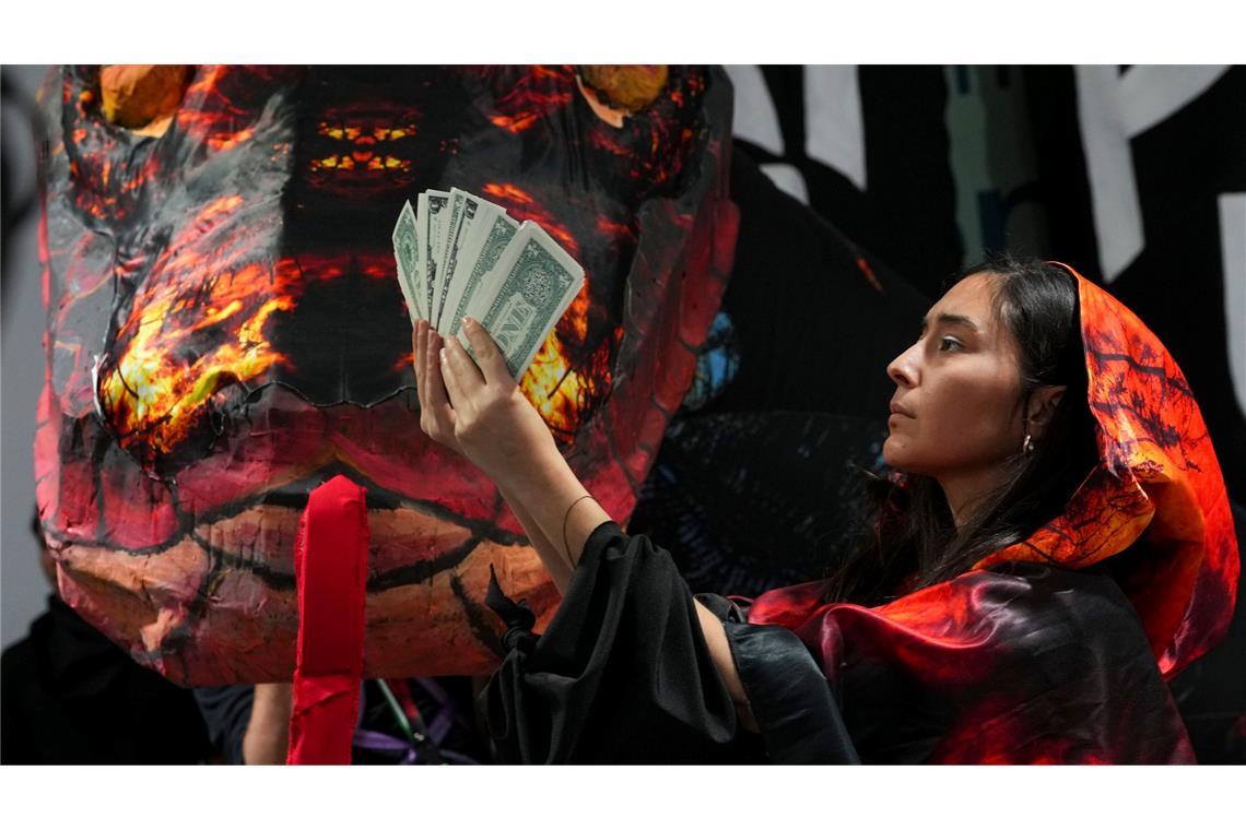 Kampf ums Geld - Der UN-Klimagipfel steht auf der Kippe Die Schlange als Symbol der gierigen Fossilindustrie bei einer Protestaktion von Klimaaktivisten in Baku.