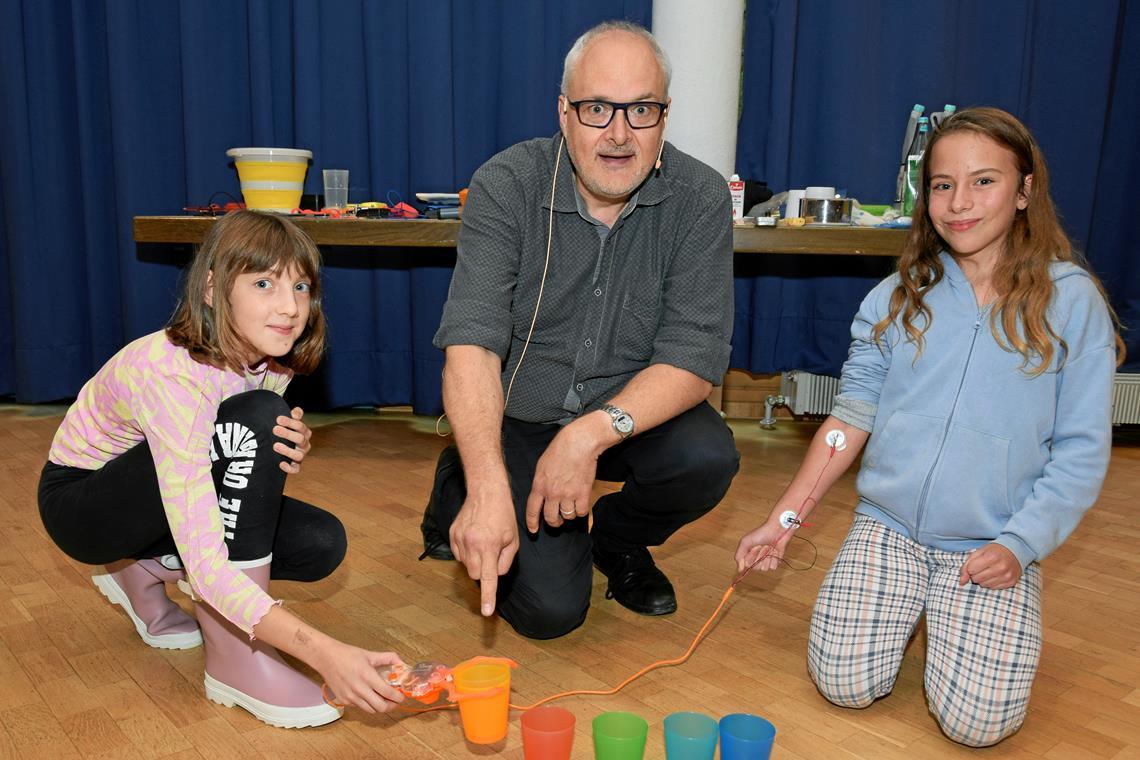 Die Schülerinnen Lea (links) und Nele stapeln unter Anleitung von Joachim Hecker miteiner Roboterklaue oder -greifzange verschiedene Becher. Foto: privat