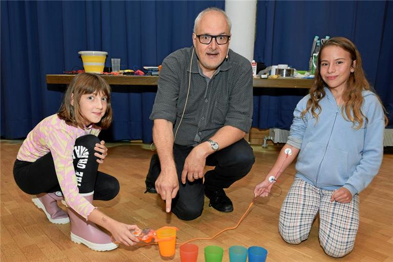 Die Schülerinnen Lea (links) und Nele stapeln unter Anleitung von Joachim Hecker miteiner Roboterklaue oder -greifzange verschiedene Becher. Foto: privat