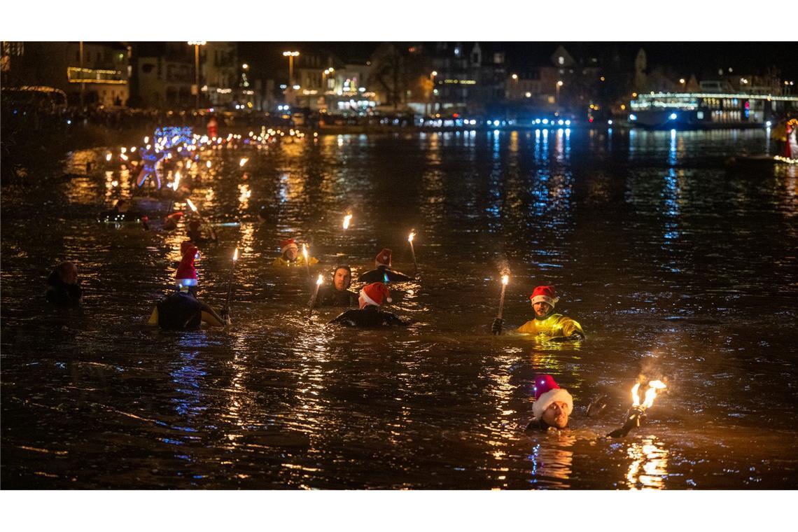 Nikolaus kommt mit dem Boot zu den Kindern Die Schwimmer tragen spezielle Tauchanzüge.