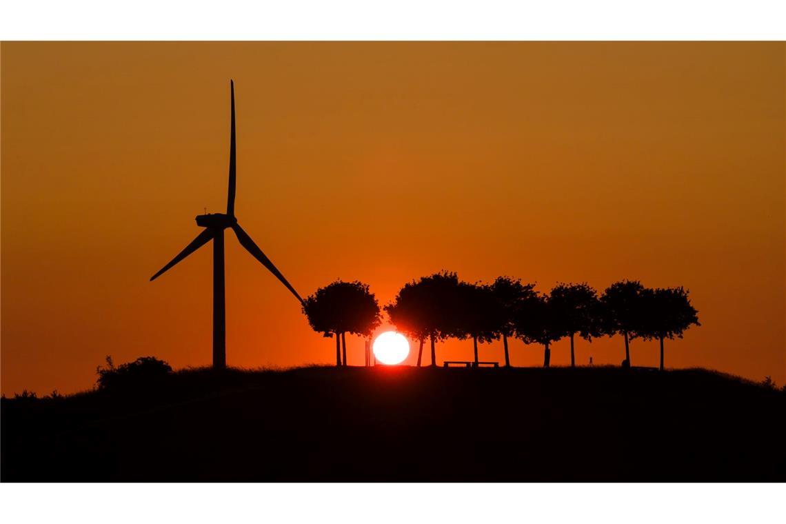 Bilder des Tages Die Sonne geht am Kronsberg hinter einem Windrad auf.