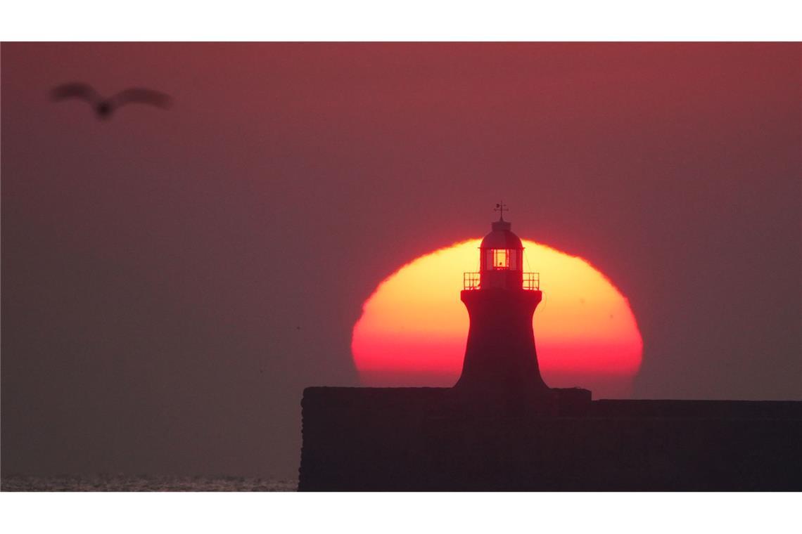 Bilder des Tages Die Sonne geht glutrot über dem Leuchtturm von South Shields an der Mündung des Flusses Tyne in Großbritannien auf.