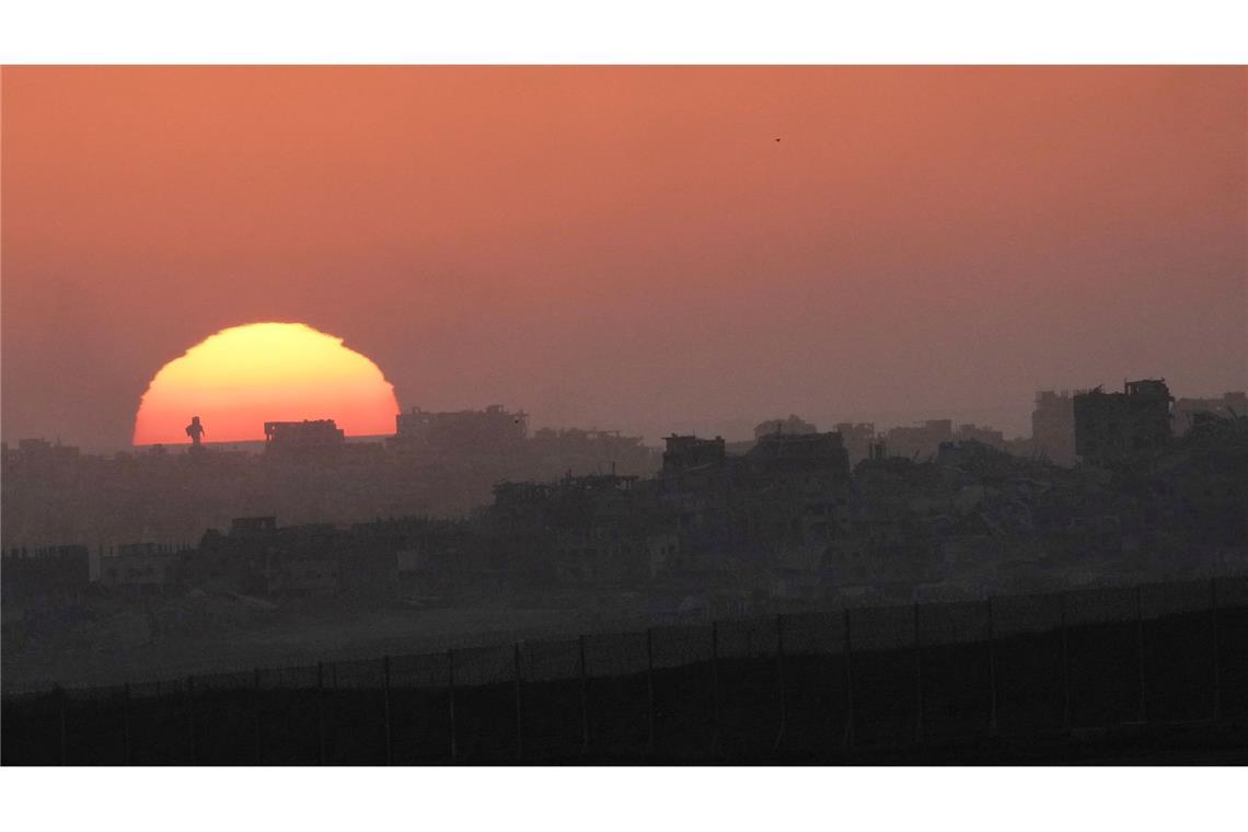 Die Sonne geht hinter zerstörten Gebäuden im nördlichen Gazastreifen nahe der Grenze zwischen Israel und Gaza im Süden Israels unter.