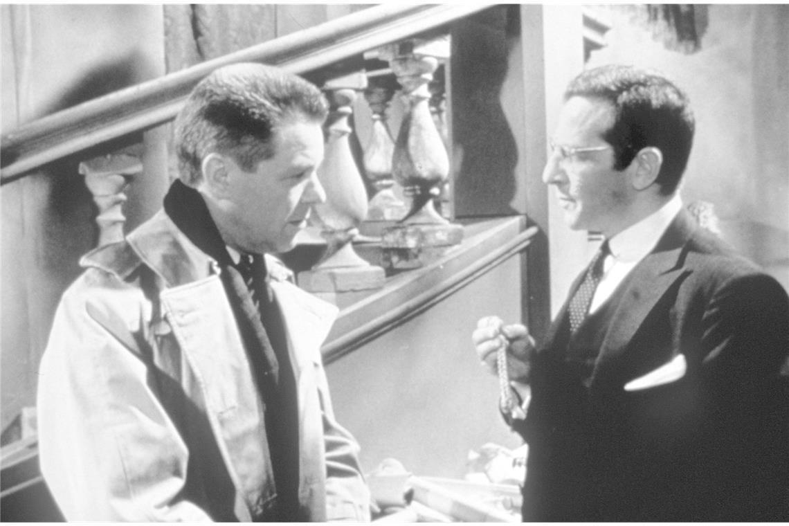 Vor 65 Jahren: Der erste Edgar-Wallace-Film feiert Premiere in Stuttgart „Die Tür mit den sieben Schlössern“ (1962): Bei Ermittlungen zu einer Mordserie trifft Inspektor Dick Martin (Heinz Drache, li.) in Schloss Selford auf eine Reihe von Erbschleichern, die einst vom verstorbenen Lord Selford je einen Schlüssel zu einer Tür bekamen, hinter der sich ein riesiges Vermögen verbirgt. Der Arzt Dr. Staletti (Pinkas Braun, re.) inszeniert daraufhin einige tödliche Anschläge.