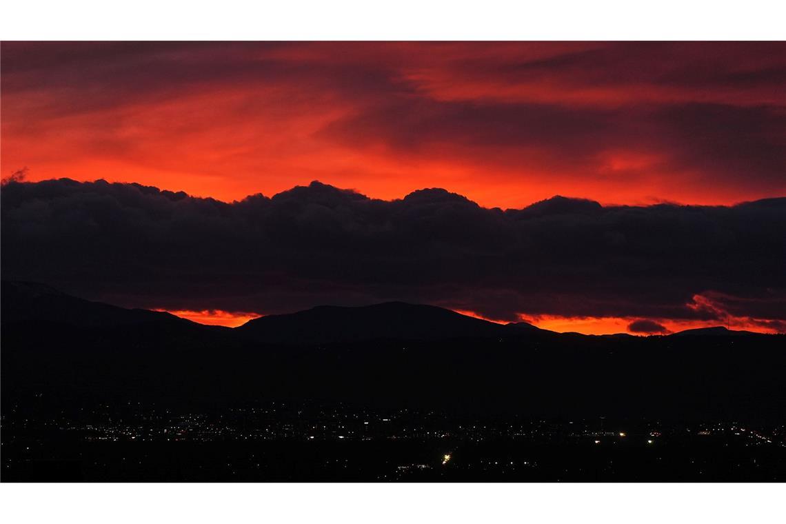 Die untergehende Sonne beleuchtet eine Wolkenbank, die über den Rocky Mountains schwebt, während ein Sturm über die Front Range von Colorado fegt.