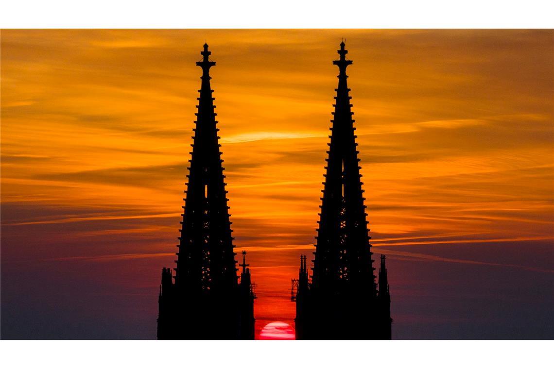 Bilder des Tages Die untergehende Sonne lässt den Himmel hinter dem Kölner Dom in orange-rot leuchten.