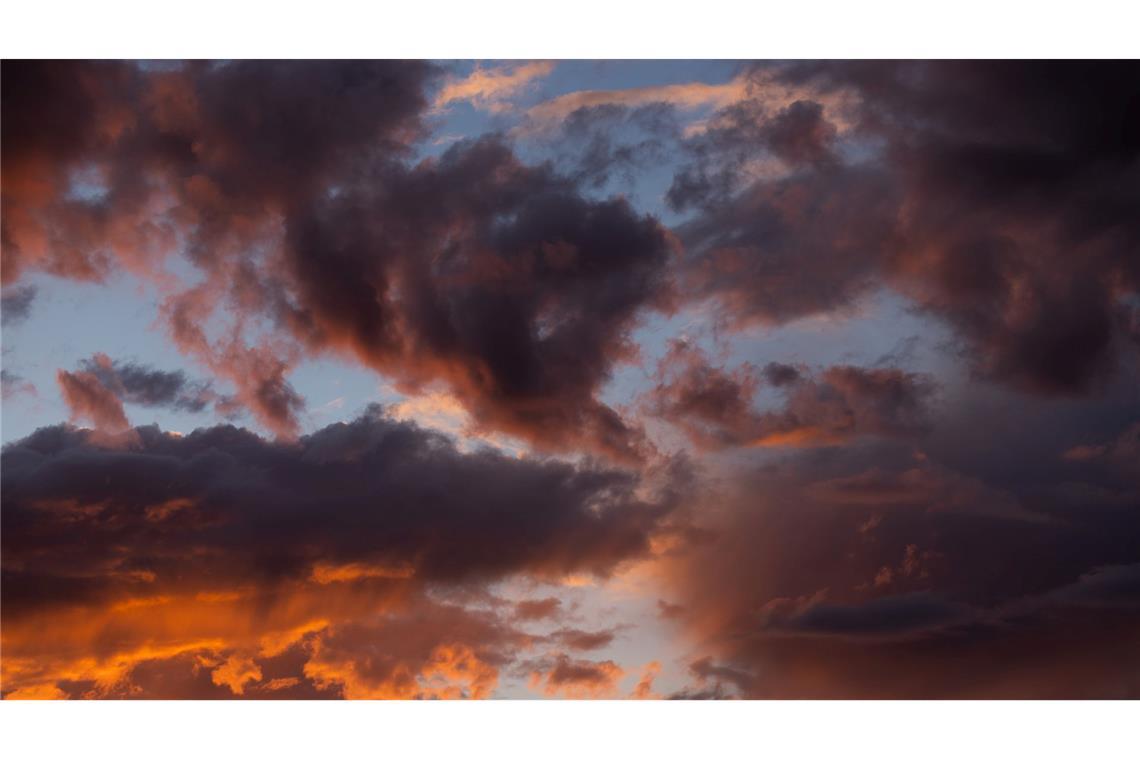 Bilder des Tages Die untergehende Sonne lässt die Wolken über Köln rötlich schimmern.