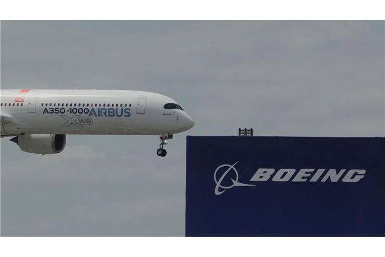 Die zwei großen Konkurrenten: Ein Airbus fliegt bei einer Vorführung auf der Luftfahrtmesse Salon du Bourget an einem Logo von Boeing vorbei.