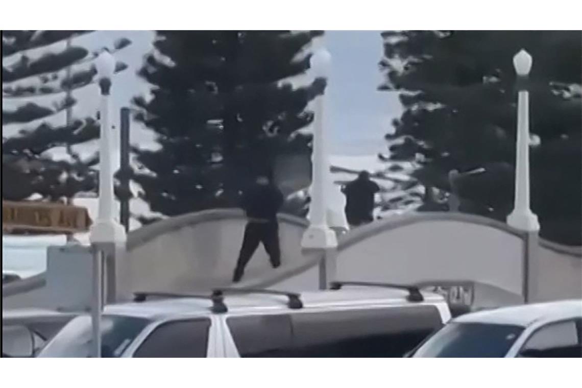 Dieser aus einem von Timothy Brant-Coles zur Verfügung gestellten UGC-Video stammende Bildschirmmitschnitt zeigt zwei schwarz gekleidete bewaffnete Täter, die mehrere Schüsse abfeuern.