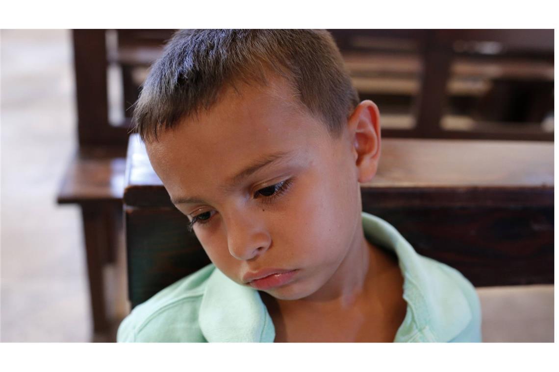 Dieser Junge hat offenkundig wenig Freude am Besuch des Gottesdienstes.