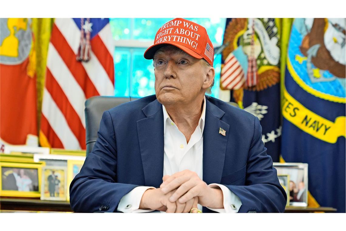 Donald Trump an seinem Schreibtisch im Weißen Haus: Er trägt eine Kappe mit der Aufschrift: „Trump hatte in allem recht!"