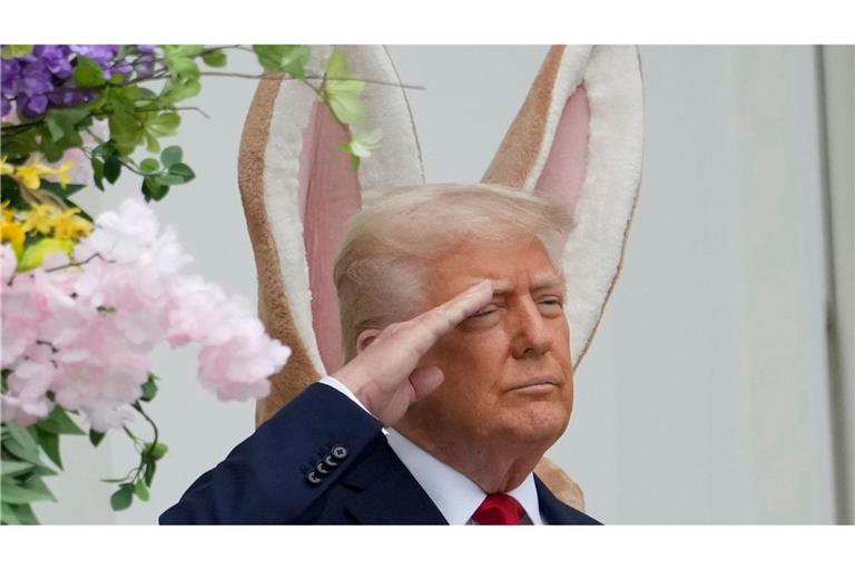 Donald Trump steht vor einem großen Osterhasen - und es sieht so aus, als hätte er sich die Ohren geliehen.