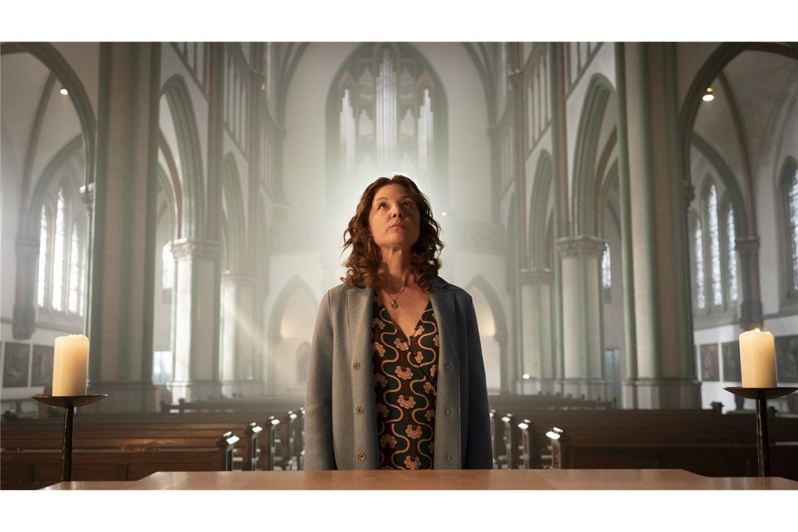 Missglückter Versicherungsbetrug Doreen Prätorius (Cordelia Wege) steht im sanften Licht der Münsteraner Kirche, das durch die hohen Fenster strömt. Mit einem Ausdruck von Ehrfurcht und Entschlossenheit blickt sie zum Altar und sucht in der sakralen Umgebung nach Antworten – oder Vergebung?
