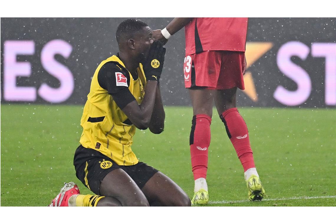 Borussia Dortmund verliert gegen Leverkusens Frühstarter Dortmunds Serhou Guirassy kniet enttäuscht auf dem Rasen.