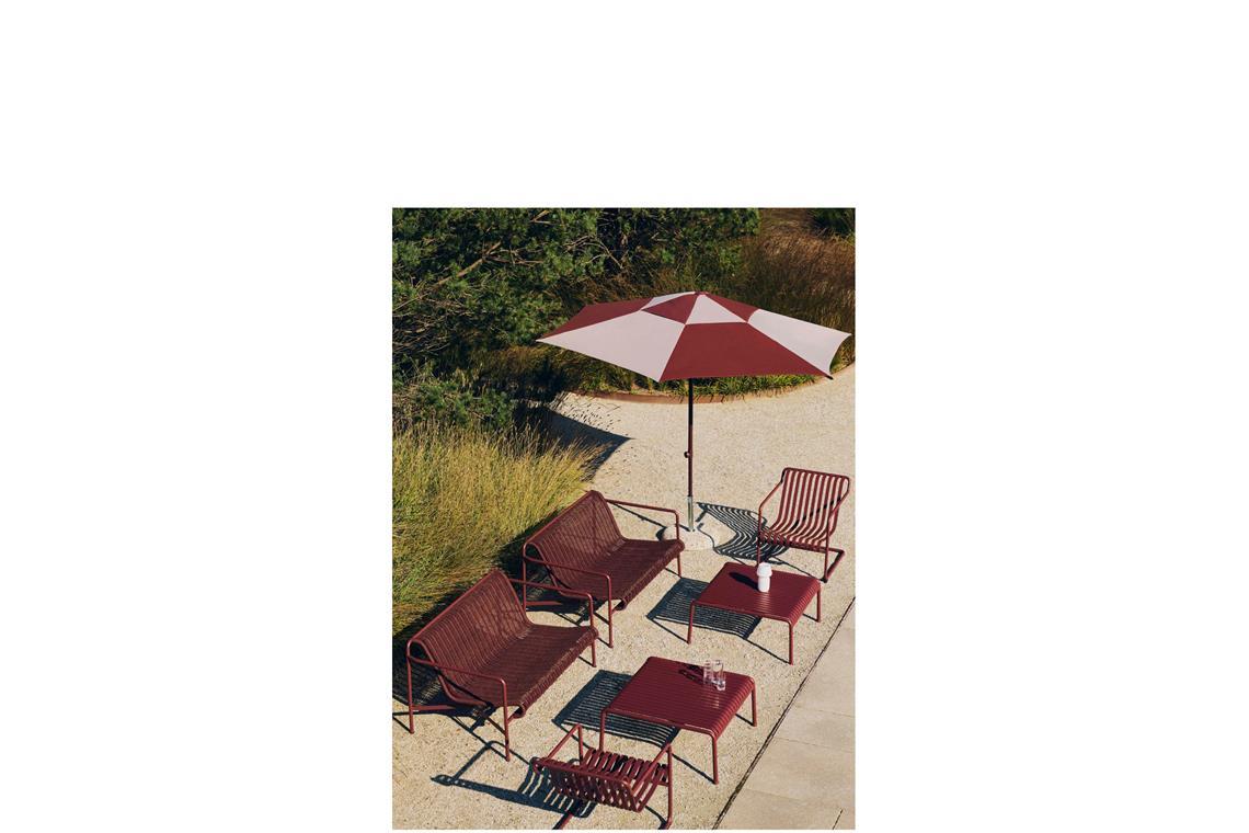 Dunkles Rot und breite Streifen: Der Sonnenschirm ist Teil der Reihe „Terrazza Parasol Square“, die Sessel und Bänke eine Weiterentwicklung der Reihe „Palissade“ name „Cantilever“ von Erwan und Ronan  Bouroullec. Beim Sofa wurden recycelte Polyester-Kabel  in den Stahlrahmen hineingewoben. Auch die Sitzfläche besteht aus Streifen.