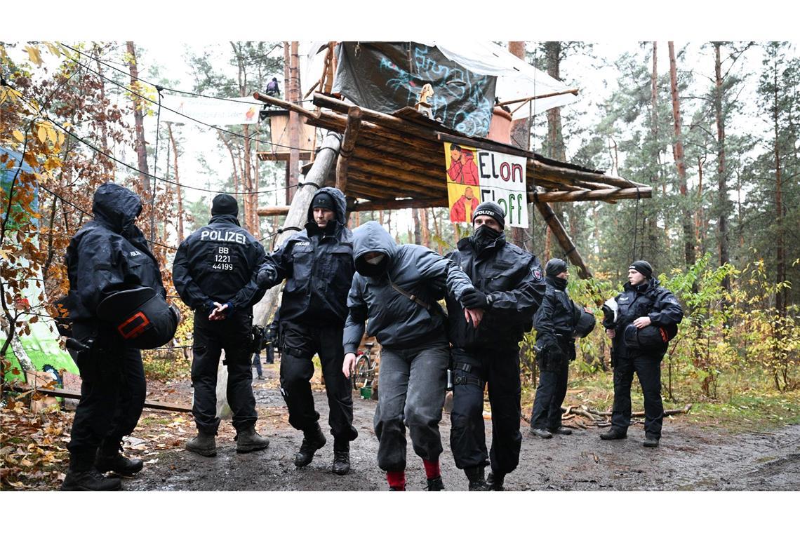 Zähe Hängepartie - Polizei löst Tesla-Protestcamp auf Ein Aktivist wird von Polizisten aus dem Protestcamp in der Nähe des Tesla-Autowerks in Grünheide abgeführt.