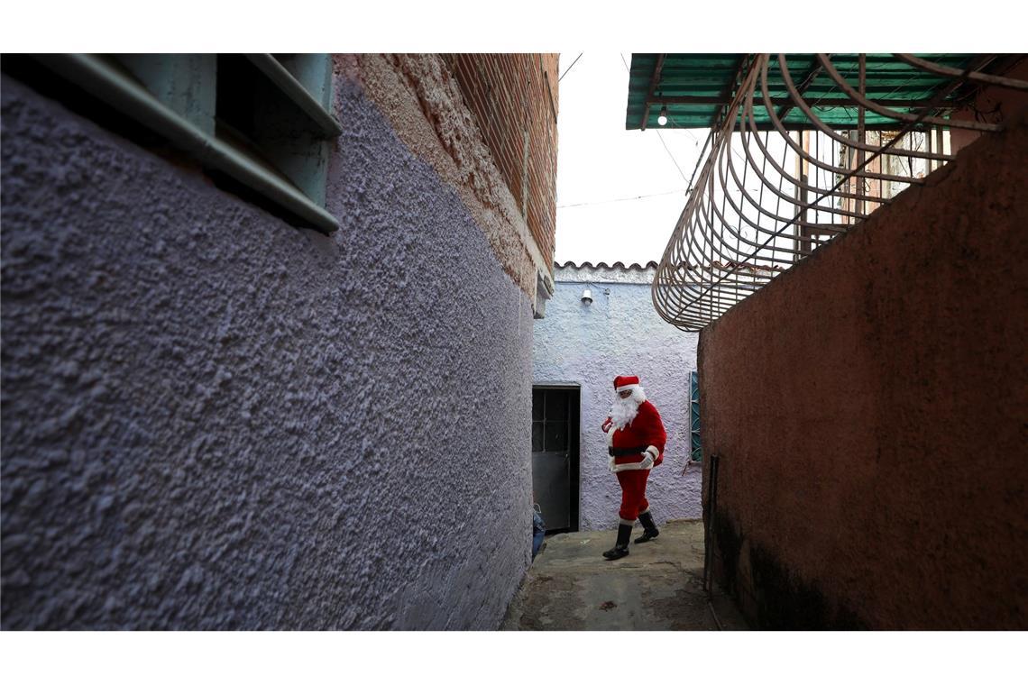 Bilder des Tages Ein als Weihnachtsmann verkleideter Mann verteilt Spielzeug an Kinder in einem als "COTA 905" bekannten Armenviertel in Caracas.