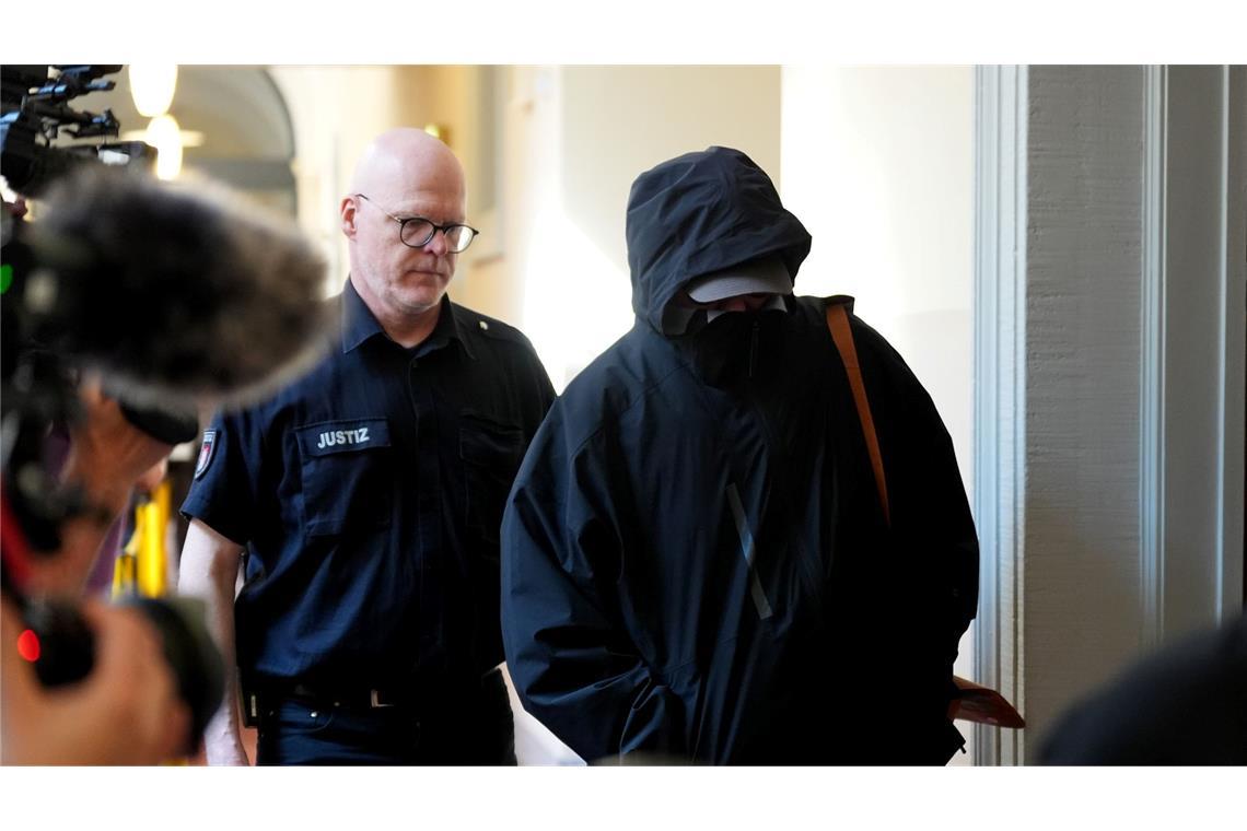 Promi-Prozess um Entführung der Block-Kinder Ein Angeklagter wird von einem Polizisten zum Gerichtssaal begleitet.