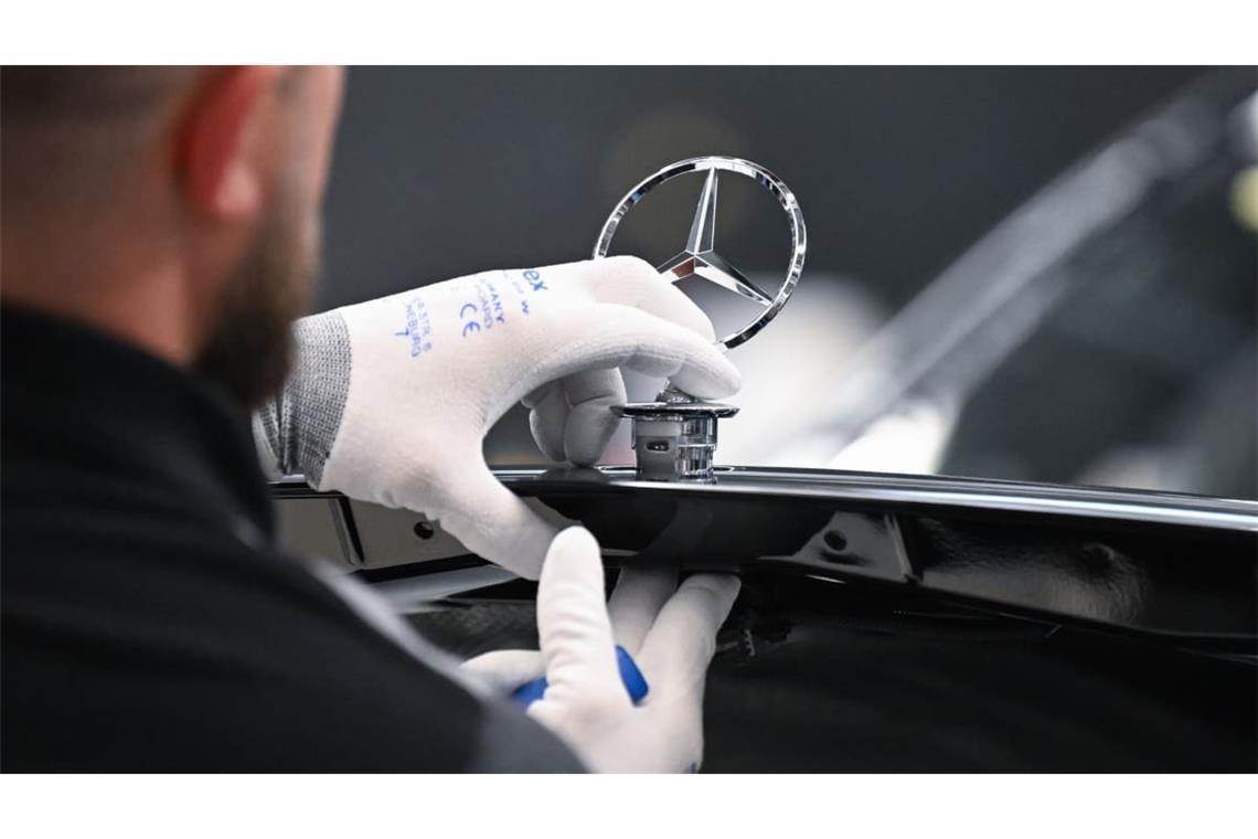 Ein Arbeiter montiert im Mercedes-Benz-Werk Sindelfingen einen Mercedes Stern auf ein Fahrzeug der S-Klasse.