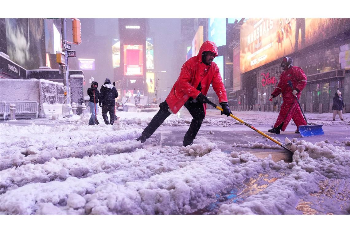 Ein Arbeiter schaufelt Schnee auf dem Times Square in New York. Ein heftiger Schneesturm zieht über den Nordosten der USA hinweg.