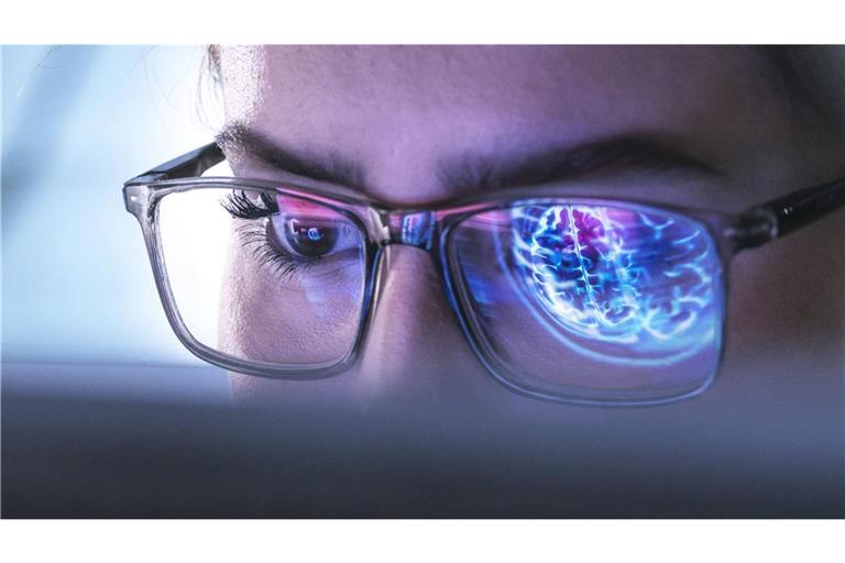 Ein Arzt untersucht mit Hilfe einer KI die Abbildung eines menschlichen Gehirns.