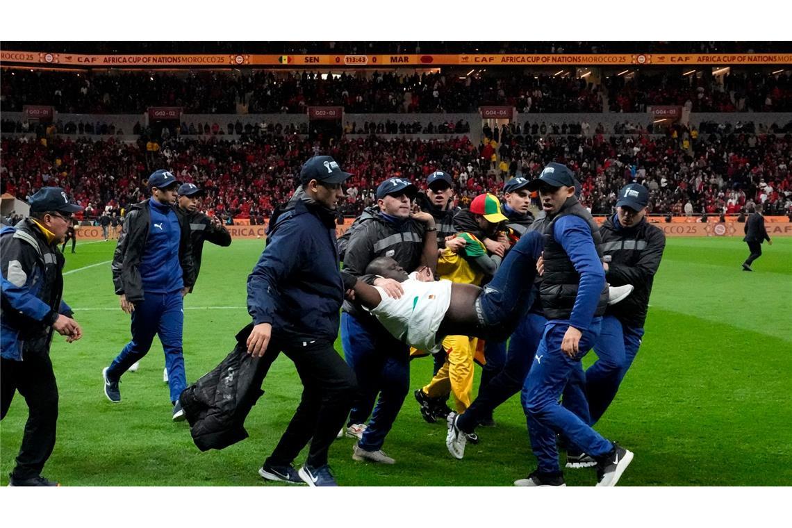 Ein auf den Platz gestürmter Anhänger des Senegals wurde von Sicherheitskräften weggetragen. (Archivbild)