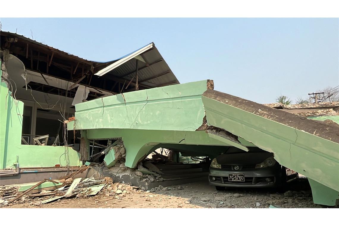 Mann in Myanmar nach fünf Tagen lebend aus Trümmern geborgen Ein Auto steckt unter einem zerstörten Gebäude in Myanmar fest.